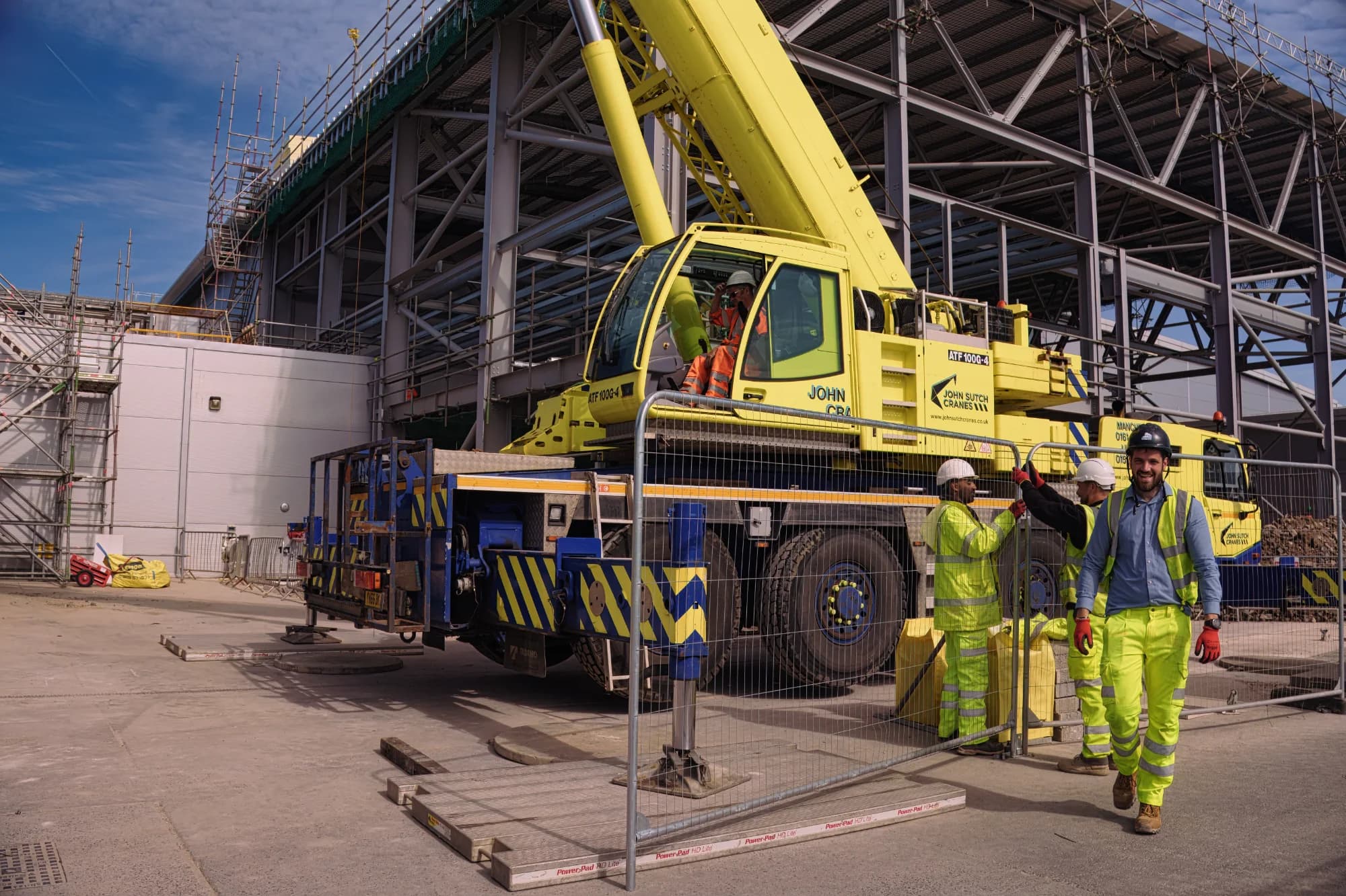 Mobile crane lifting a structural steel section during erection — operation governed by BS 7121 code of practice for safe use of cranes