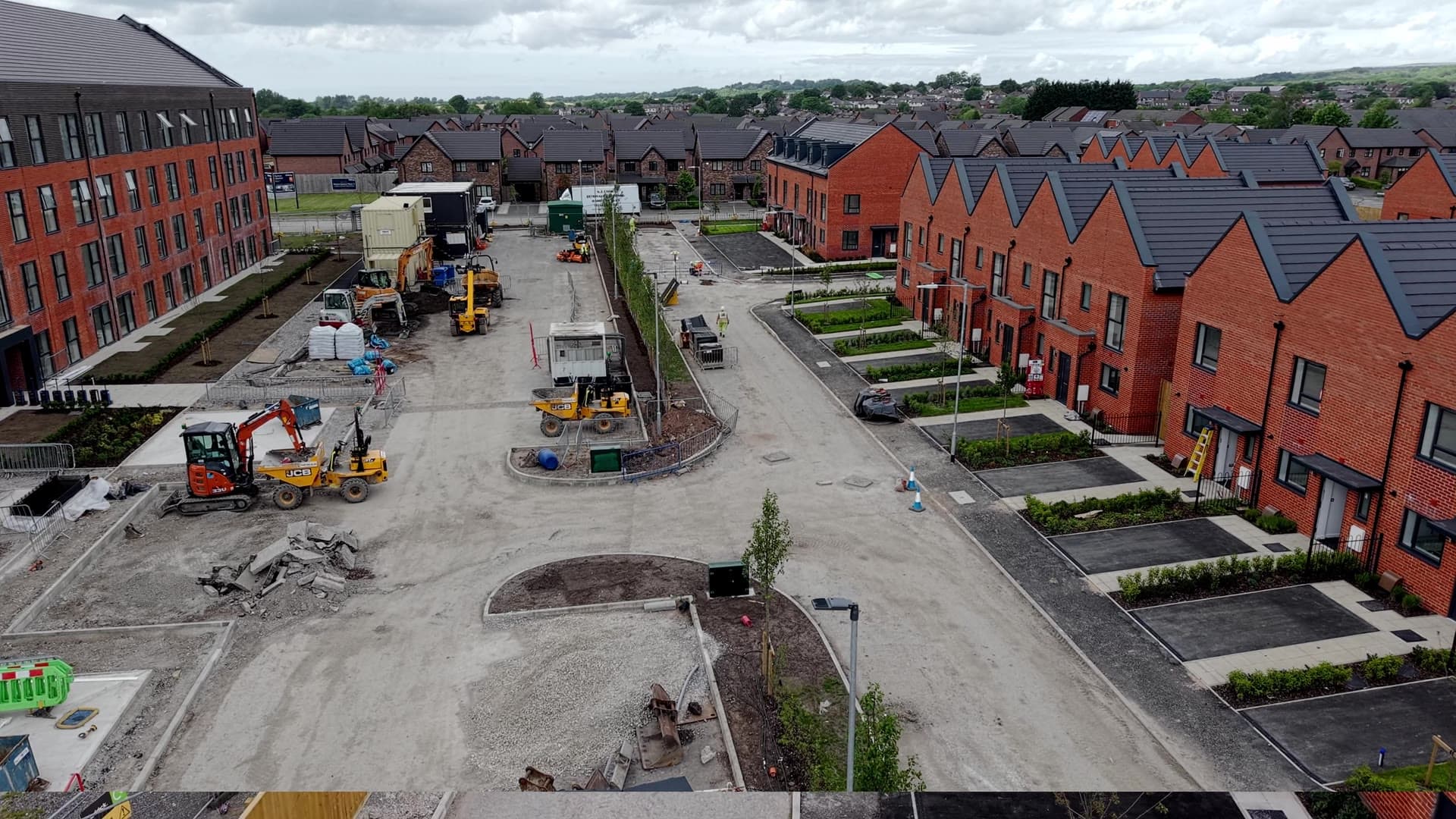Rows of new affordable homes at Rivington Chase, Horwich, with the heritage Loco Works buildings beyond