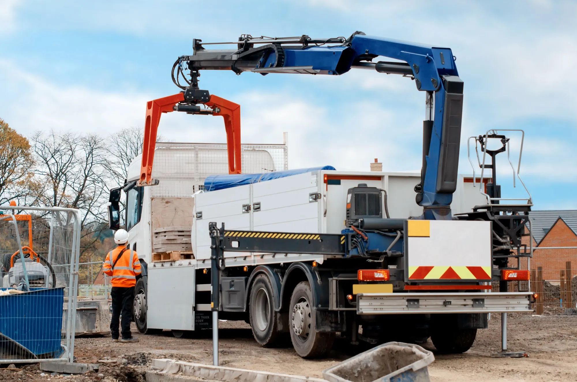 Lorry loader (HIAB) offloading a delivery on a UK construction site — a vehicle-mounted crane operation requiring a lorry loader lift plan